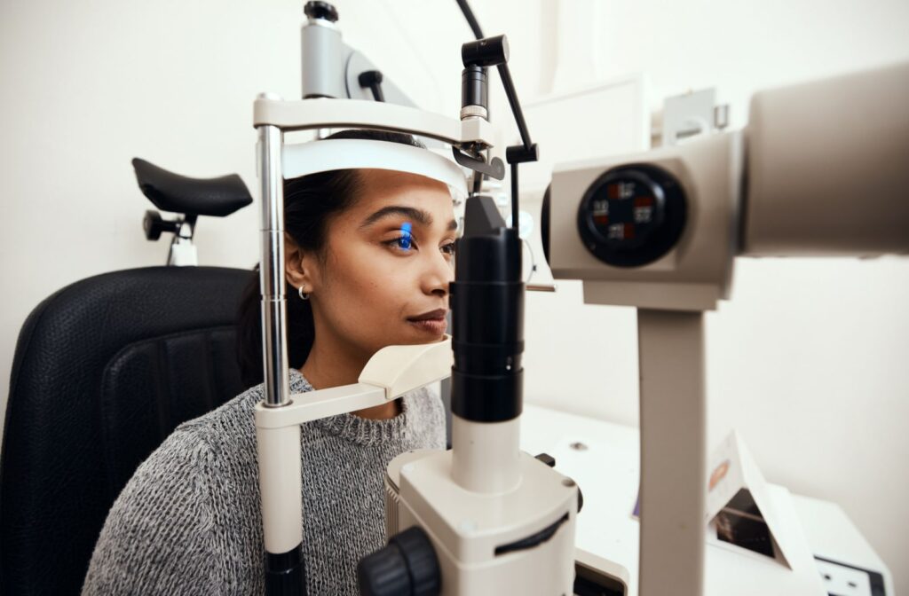 A female patient has her eyes examined with a slit lamp