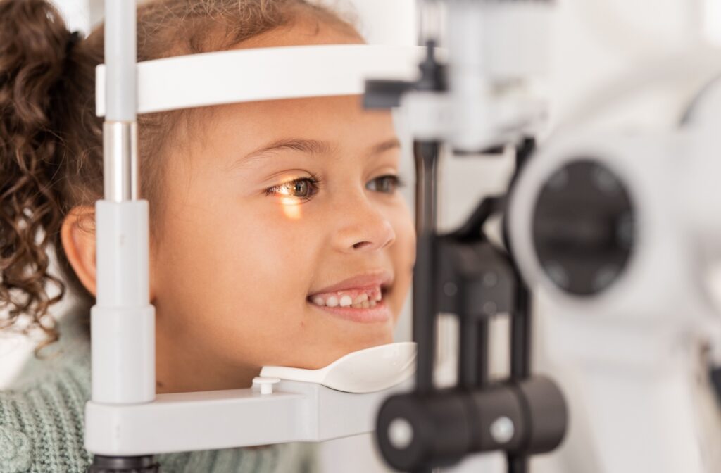 A young girl getting an eye exam with a slit lamp