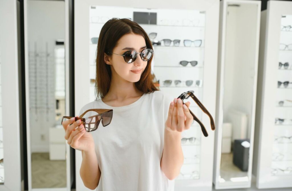 A young woman at the optometrist trying to choose between polarized and non-polarized sunglasses.