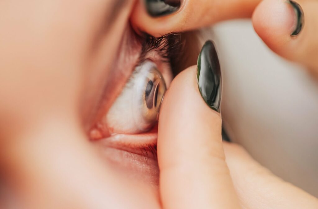 Close-up of fingers adjusting a contact lens in an eye, addressing fears of lenses getting lost.