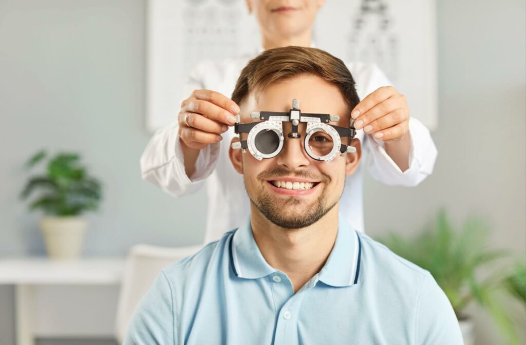 Patient smiling at camera while wearing eye exam testing instrument.