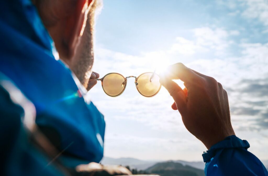 Close-up of polarized sunglasses held up to the sun, showing lens clarity and light filtering.