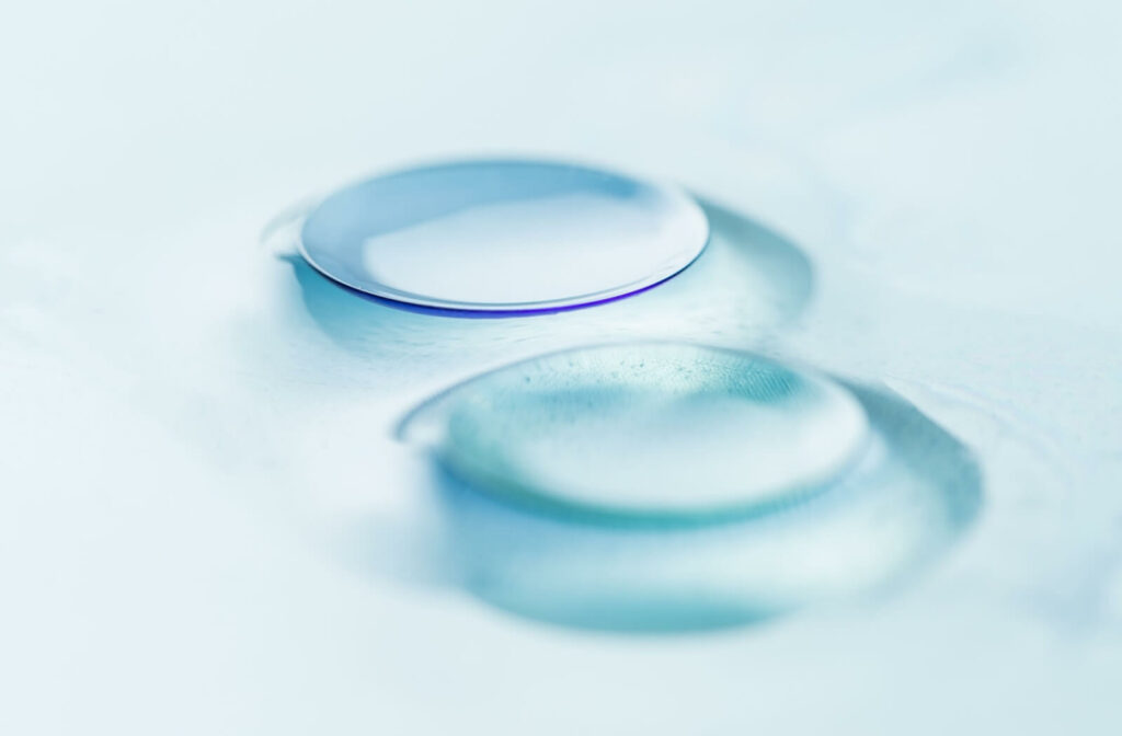 Close-up of a rigid gas-permeable contact lens with a light reflection on its surface.