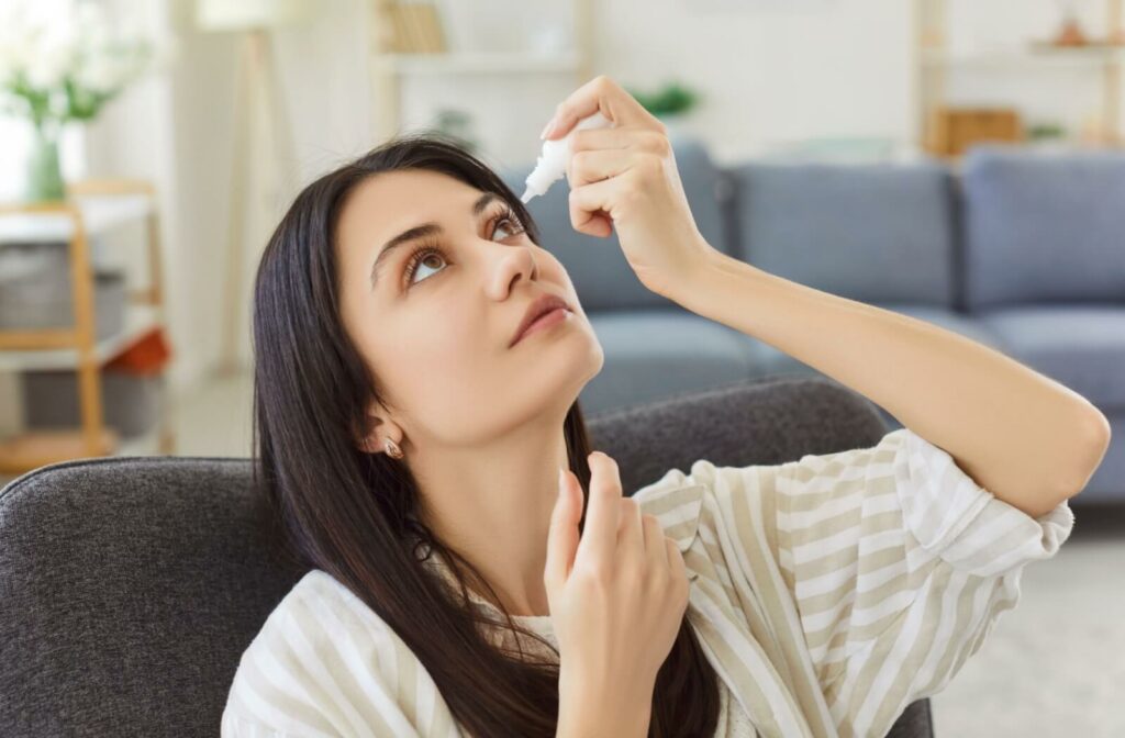 Person undergoing an eye exam with a slit lamp as a blue light shines on the surface of their eye.
