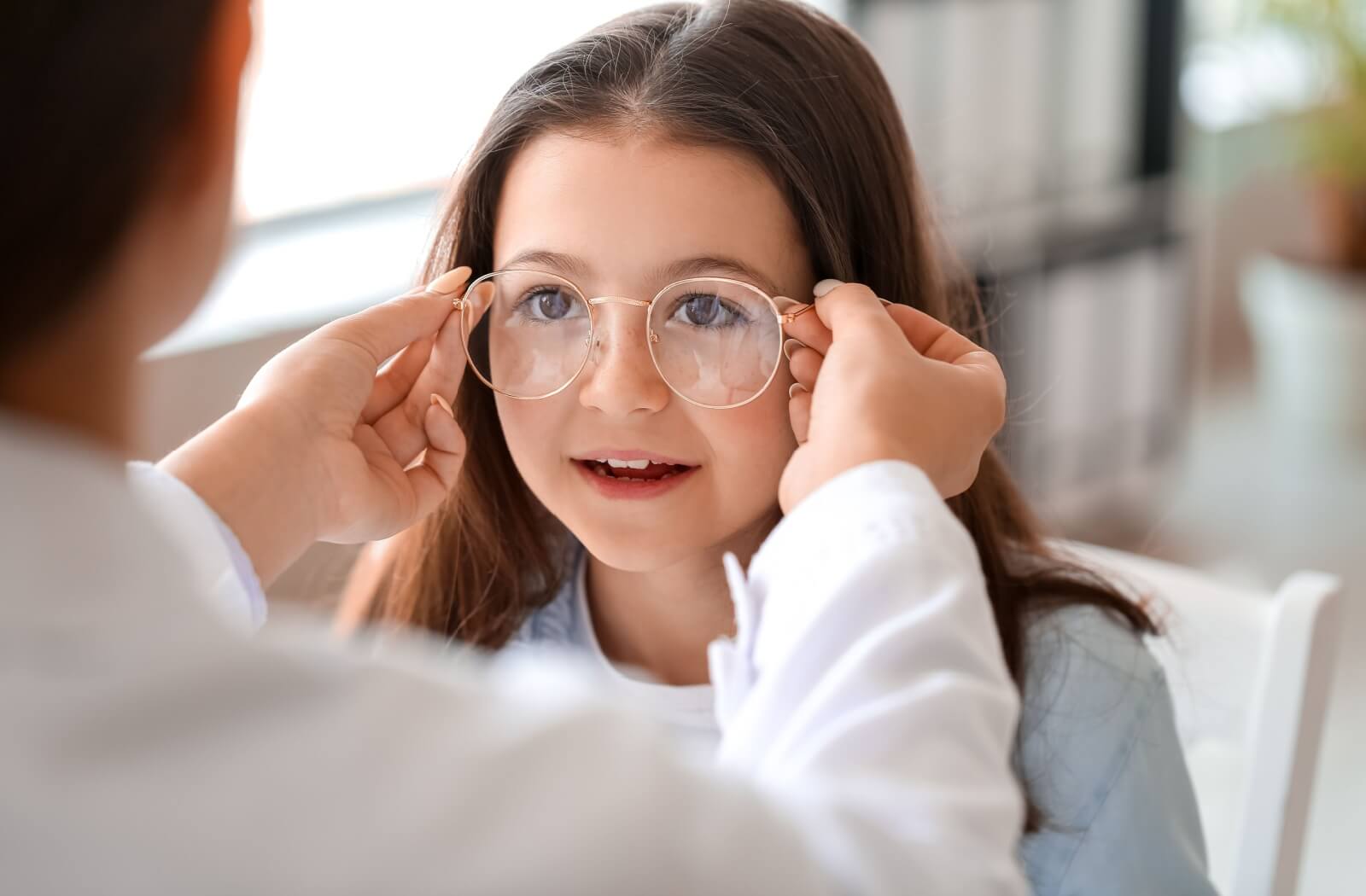 Little girl with new eyeglasses at ophthalmologist's office